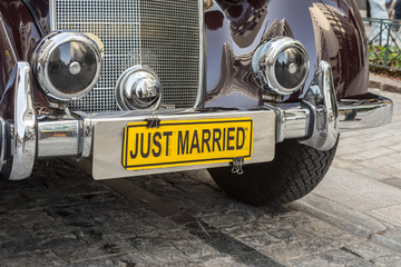 One classical, polished old car used for transportation of wedding with a yellow 