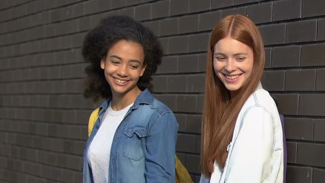Female teens taunting smart girl in schoolyard, appearance bullying, disrespect