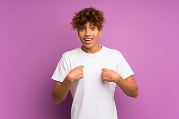 Young african american man over isolated purple wall with surprise facial expression