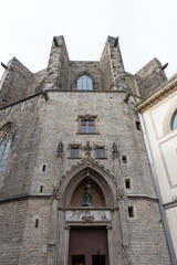 Fototapeta na wymiar Basilica de Santa Maria del Mar, detail of the secondary entrance in tipical Catalan Gothic, Barcelona. Spain.