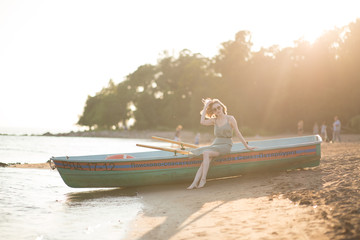 Young slim girl sitting on board rescue boat on shore