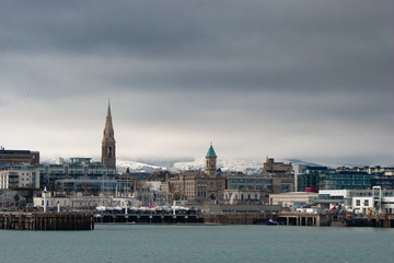 Snow Dun Laoghaire town with snowed hills in background
