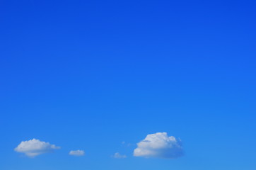 small fluffy clouds in the blue sky.