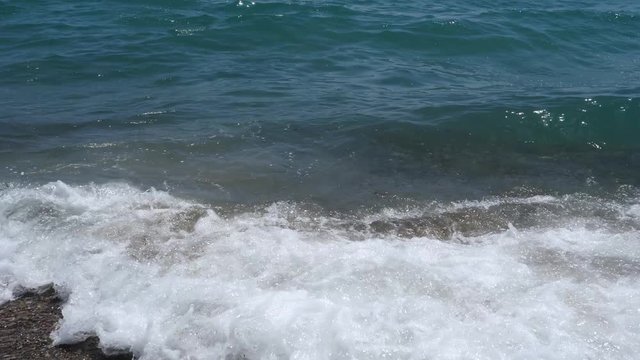 Footage of a waves breaking against a beautiful sand beach in the italian coas close up