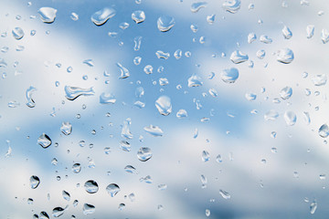 water drops (rain) on glass against a cloudy sky