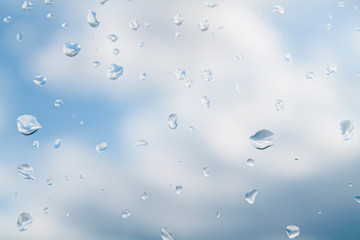 water drops (rain) on glass against a cloudy sky