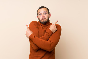 Colombian man with turtleneck sweater pointing to the laterals having doubts