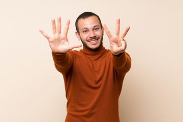 Colombian man with turtleneck sweater counting eight with fingers