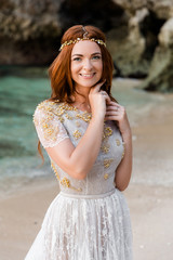 Fototapeta na wymiar Portrait of happy smiling bride in wedding dress at ocean beach