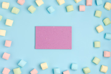 Blue paper background with marshmallow and notepad. Place for your text. Cozy sweet background