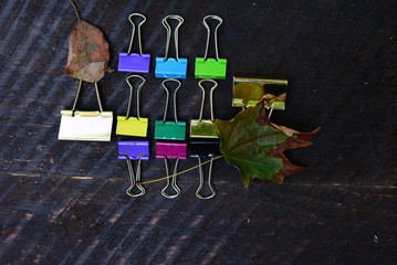 multi colored binder clips on barn board