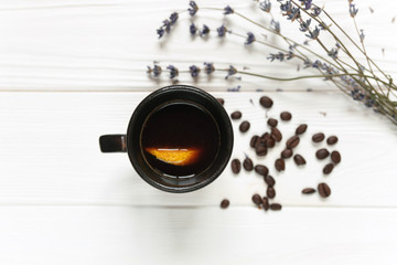 Cup of coffee with lemon on white table, with lavender and coffee beans