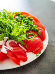 Greek salad with rucola on stone table