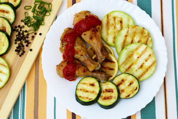 grilled chicken, zucchini and lemon, top view, bright background