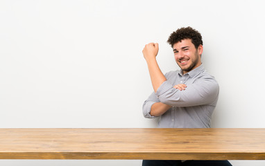 Young man with a table doing strong gesture