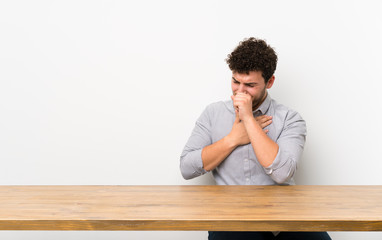 Fototapeta premium Young man with a table is suffering with cough and feeling bad