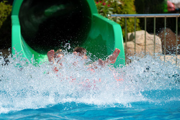 People having fun at aqua park. Extensive splashes left by people sliding down slide in waterpark.