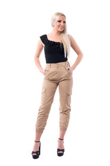 Luxury street style look fashion blonde woman in military trousers smiling and looking away.  Full body isolated on white background.