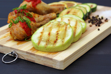 grilled chicken with vegetables on a wooden board