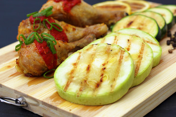 grilled chicken with vegetables on a wooden board