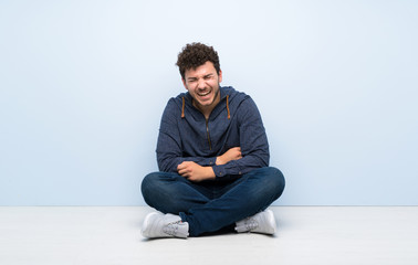 Young man sitting on the floor smiling a lot