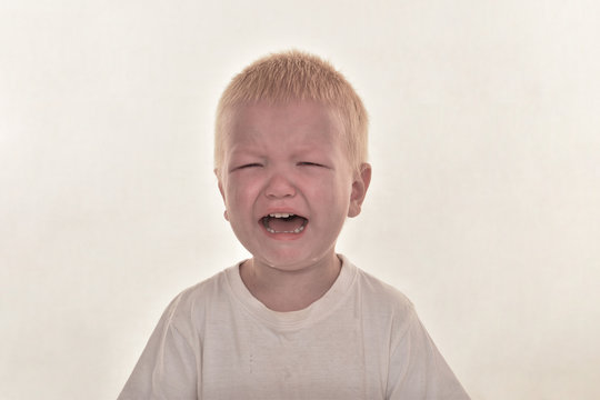 Blonde boy cries with tears. Upset child. Violence in family over children. Concept of bullying, depressive stress or frustration. Kid close up view. Pure authentic emotion. Copy space for text