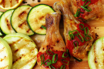 grilled chicken, zucchini and lemon, top view, wooden board
