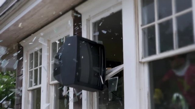 TV flying through a window in slow motion