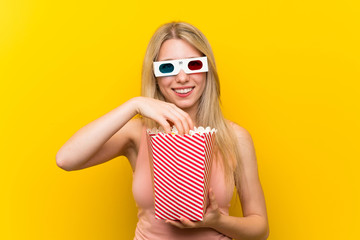 Young woman with popcorns over pink wall