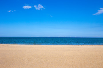 Fototapeta na wymiar White sandy beach with ocean and deep blue sky in North Wales UK