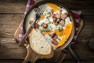 Tasty cooked egg with chopped sausages.