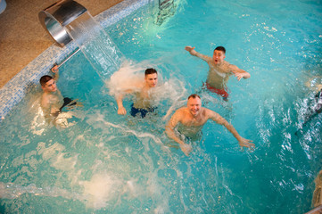 top view of 4 men relaxing in swimming pool in a spa centre