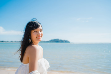 Fototapeta na wymiar Beautiful young Asian woman happy relax walking on beach near sea. Lifestyle women travel on beach concept.