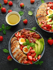 Fototapeta na wymiar Chicken Cobb salad with strawberries, bacon, avocado and boiled eggs