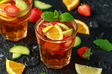 Refreshing Pimms Cocktail with Fruit and vegetables on rustic black table