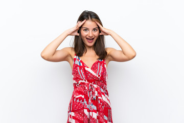 Caucasian girl in red dress over isolated white wall with surprise expression
