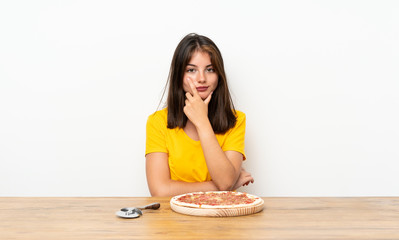 Caucasian girl with a pizza thinking an idea