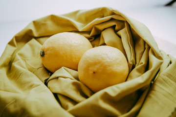 fresh lemon with water droplets above the brown cloth