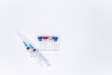 Veterinary and medical glass vials and two syringes for vaccination on a white isolated background. Liquid drug or vaccine to treat people and Pets against viruses, diseases, flu, rabies. Copy spase