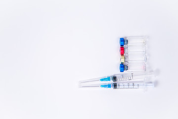 Obraz premium Veterinary and medical glass vials and two syringes for vaccination on a white isolated background. Liquid drug or vaccine to treat people and Pets against viruses, diseases, flu, rabies. Copy spase