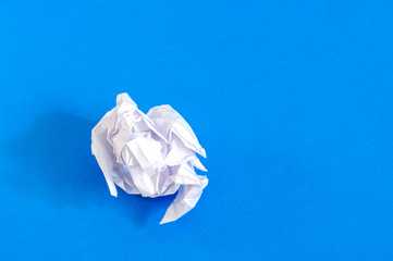 crumpled piece of paper on a blue background