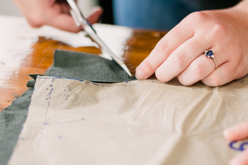 Obraz na płótnie Canvas Person Cutting a Pattern from Fabric