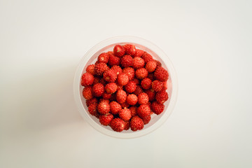 Strawberry berry in a glass on a light background