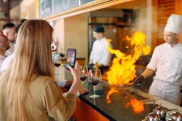 The chef prepares food in front of the visitors in the restaurant