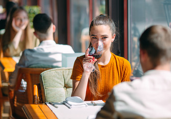 A young couple drinking wine in a restaurant near the window.