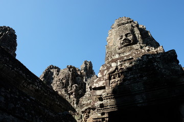 A huge human face built of stone blocks. Huge human faces on the towers of the Bayon temple in...