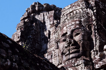 A huge human face built of stone blocks. Huge human faces on the towers of the Bayon temple in...