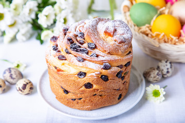 Craffin (Cruffin) with raisins and candied fruits. Easter Bread Kulich and painted eggs. Easter Holiday. Close-up.