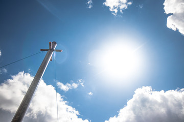 Metal Pole behind beautiful blue sky with fluffy filled clouds showing peaceful and calm relaxing day
