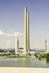 Obraz premium Tall Stacks of a Coal Power Plant by a River